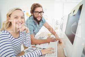 Portrait of happy business people at computer desk