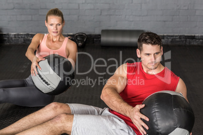 Muscular couple doing ball exercise