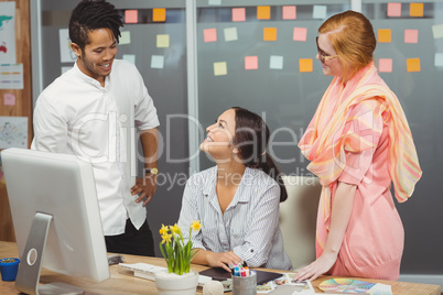 Happy business people using computer in office