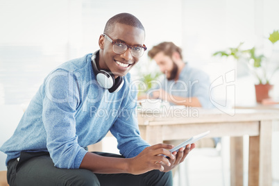 Portrait of smiling man with headphones while using digital tabl