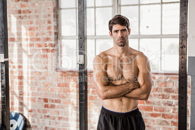 Portrait of a shirtless man with arms crossed