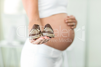 Close-up of baby shoes on woman palm