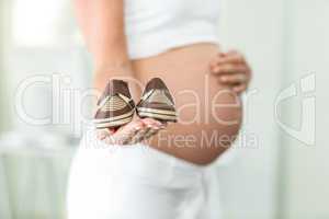 Close-up of baby shoes on woman palm