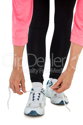 Low section of woman tying shoelace