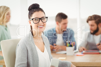 Portrait of happy woman wearing eyeglasses holding smartphone