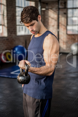 Side view of a man lifting kettlebell
