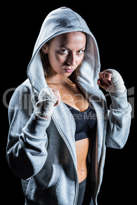 Portrait of female boxer in hood with fighting stance