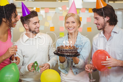 Portrait of happy businesswoman holding birthday cake