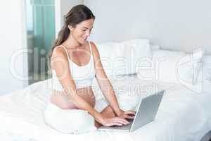 Happy woman typing on notebook