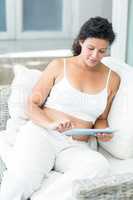 Woman using tablet pc on sofa