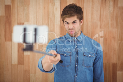 Hipster sticking out tongue while taking selfie