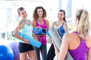 Women smiling looking at each other in fitness studio
