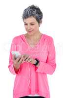 Mature woman using cellphone while listening music
