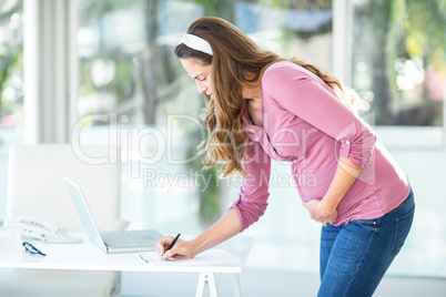 Businesswoman writing note on paper