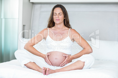 Woman exercising yoga on bed