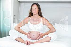 Woman exercising yoga on bed