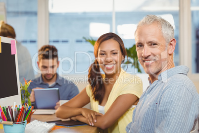 Smiling business people working in creative office with employee