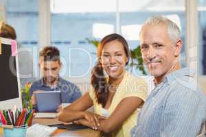 Smiling business people working in creative office with employee