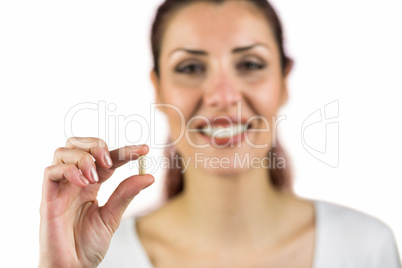 Close-up portrait of smiling woman holding pill