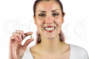 Close-up portrait of smiling woman holding pill