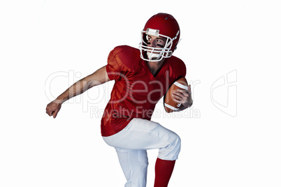 Rugby player holding the ball while lifting leg