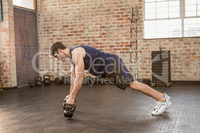 Man doing push up holding kettlebell