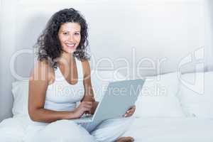 Portrait of beautiful smiling pregnant woman using laptop
