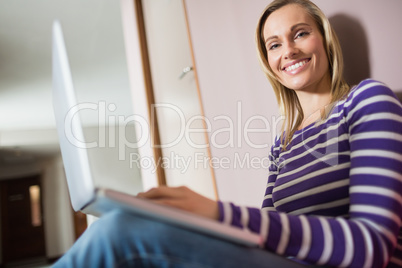 Happy female student using laptop