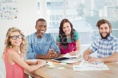 Portrait of smiling business professionals at desk