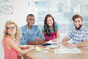 Portrait of smiling business professionals at desk