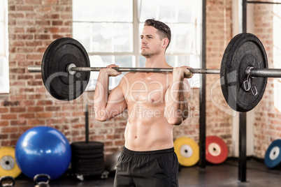 Muscular serious man doing weightlifting