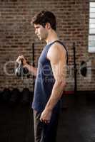 Side view of man lifting kettlebell