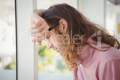 Hipster with eyes closed leaning on window