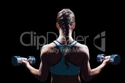 Rear view of braided hair woman lifting dumbbells