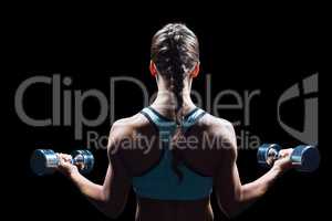 Rear view of braided hair woman lifting dumbbells