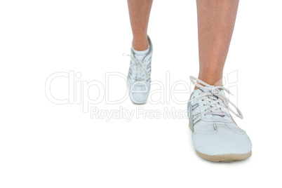Low section of woman wearing sports shoe running