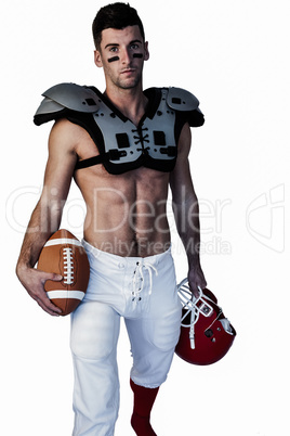 Portrait of rugby player holding ball and helmet