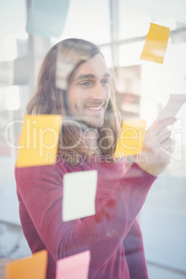 Happy hipster holding sticky note