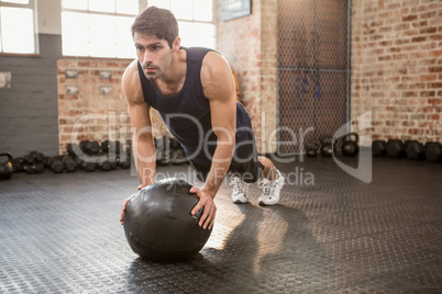 Man doing push ups on medicine ball