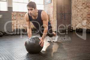 Man doing push ups on medicine ball