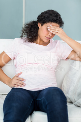 Upset pregnant woman with hand on forehead