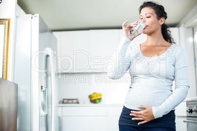 Pregnant woman drinking a glass of water