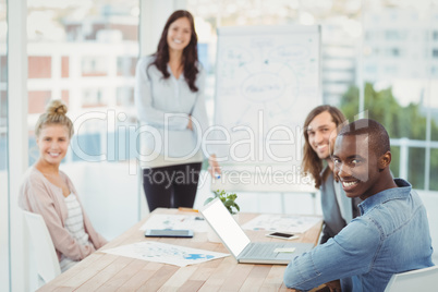 Portrait of smiling business people while coworker standing by w