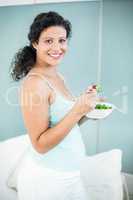 Pregnant woman holding bowl of salad