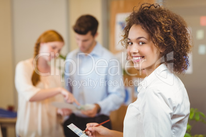 Smiling businesswoman writing on document