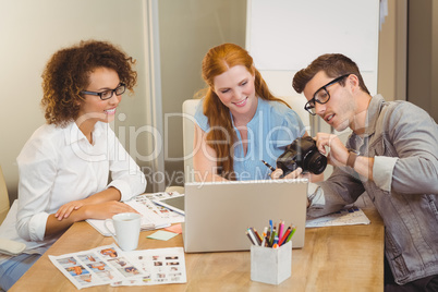 Businessman showing something on camera to female colleagues