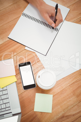 Businessman writing on spiral notebook