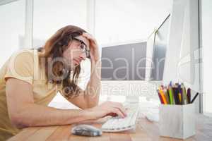 Frustrated hipster working on computer