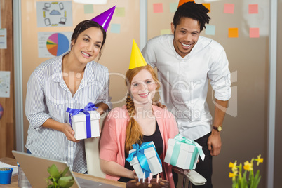 Portrait of happy colleagues holding gifts
