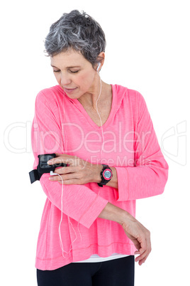 Woman adjusting armband while listening music